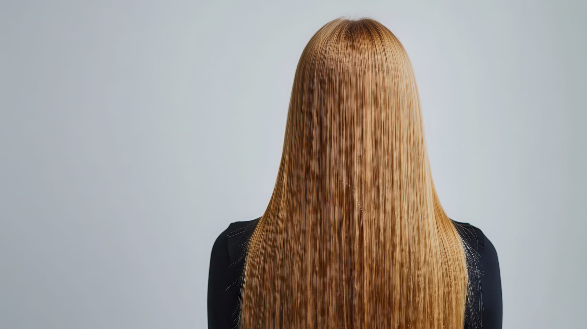 Zu sehen ist der Rücken einer Frau mit langen roten Haaren.