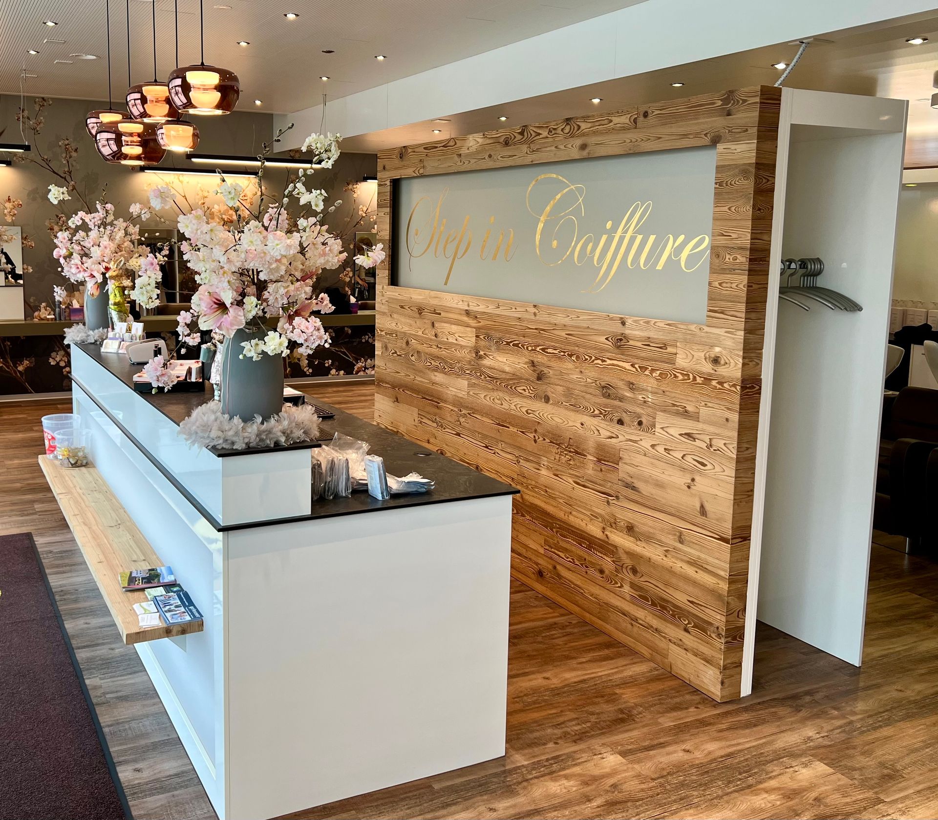 Ein Salon mit Holzwand und langem Tresen.