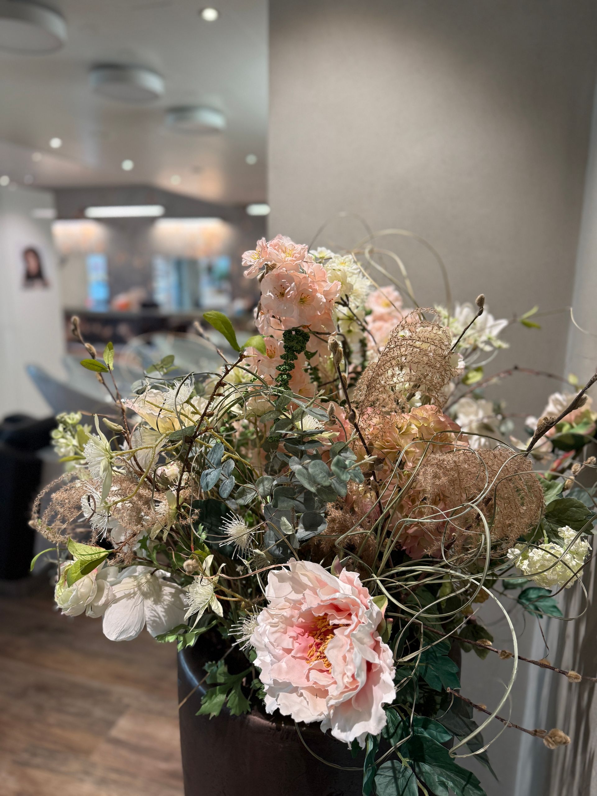 Eine Nahaufnahme einer mit Blumen gefüllten Vase in einem Raum.