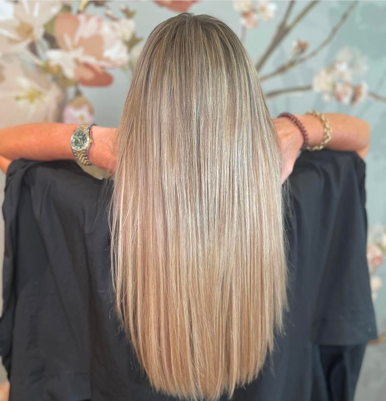 Eine Frau mit langen braunen Haaren trägt einen schwarzen Umhang.