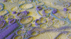 Abstract 3D landscape of yellow, blue, and purple geometric shapes, with circular and linear patterns.