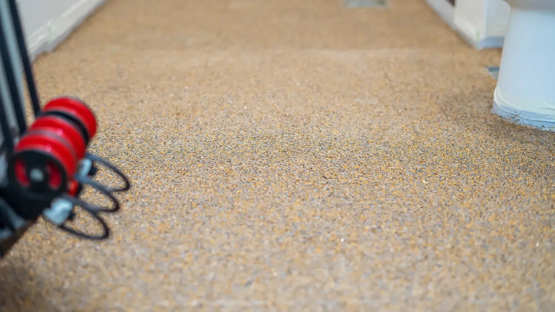 A close up of a rolling exercise machine on a carpeted floor.