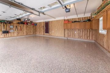 A large empty garage with a concrete floor and wooden walls.