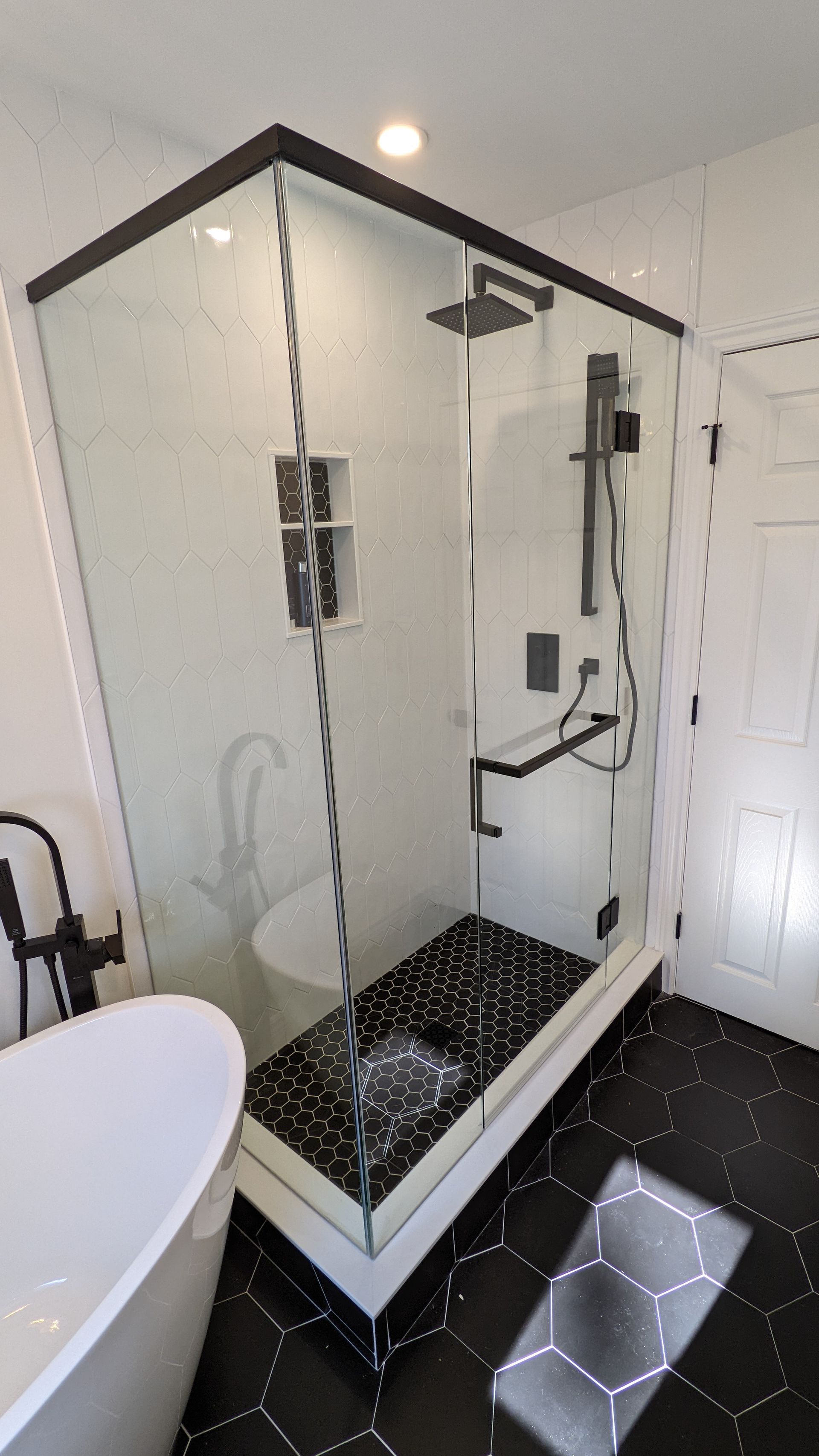 A bathroom with a walk in shower and a bathtub.