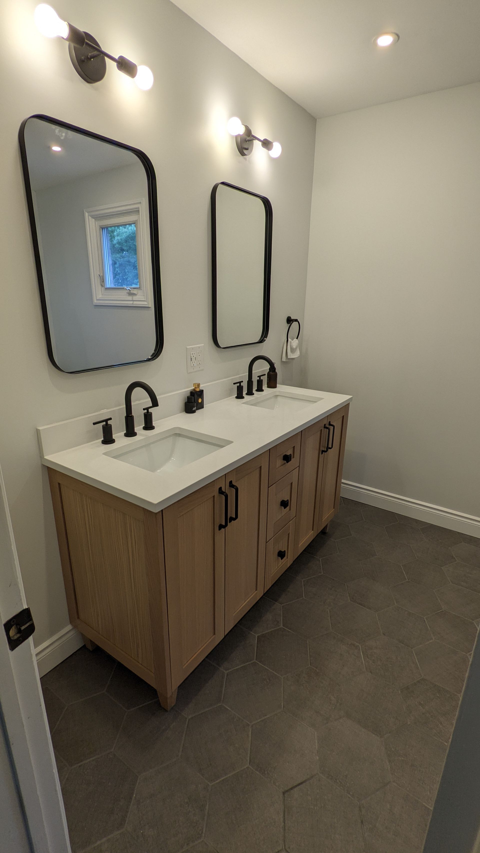 A bathroom with two sinks and two mirrors.