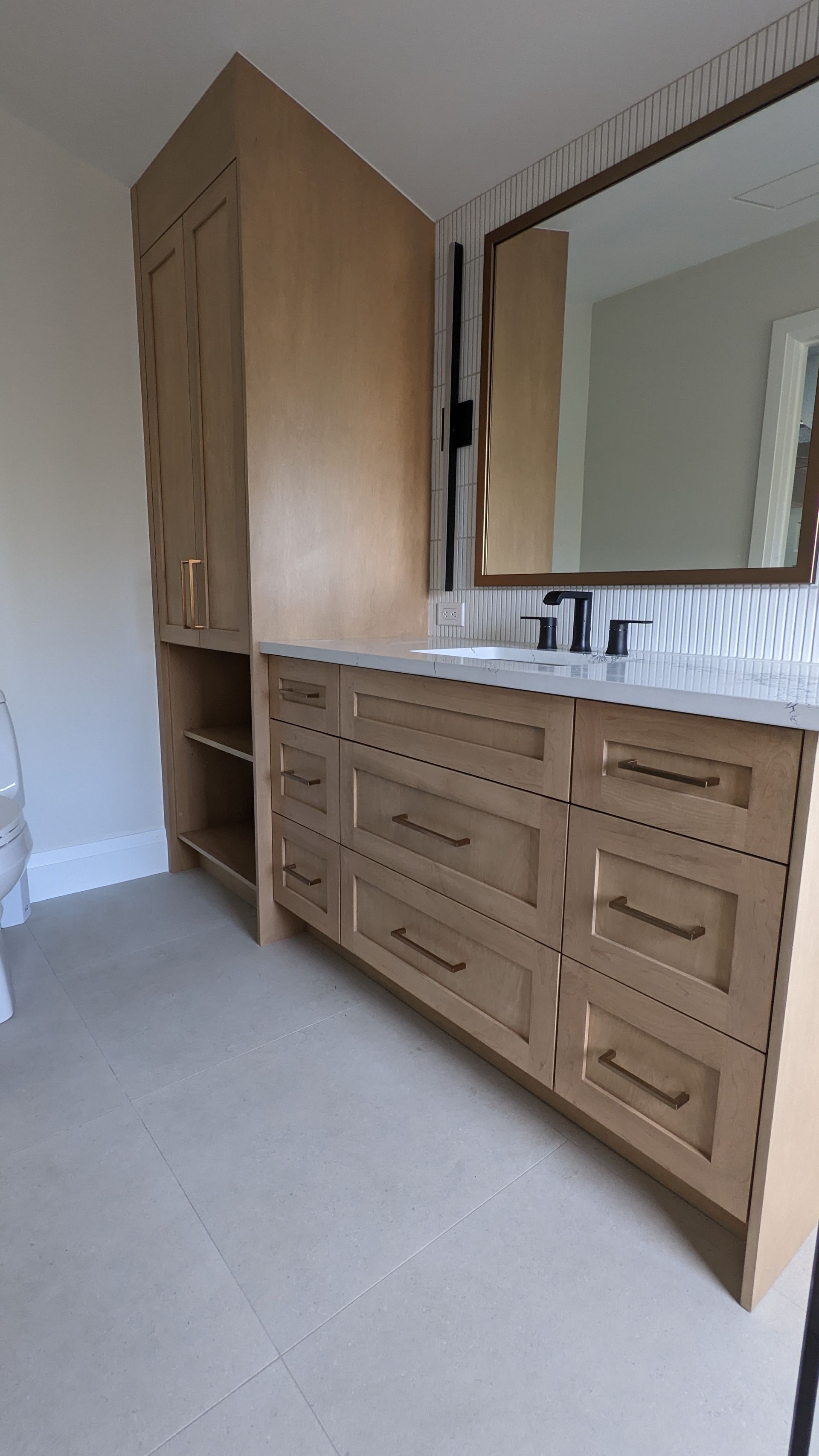 A bathroom with a sink , mirror and cabinets.