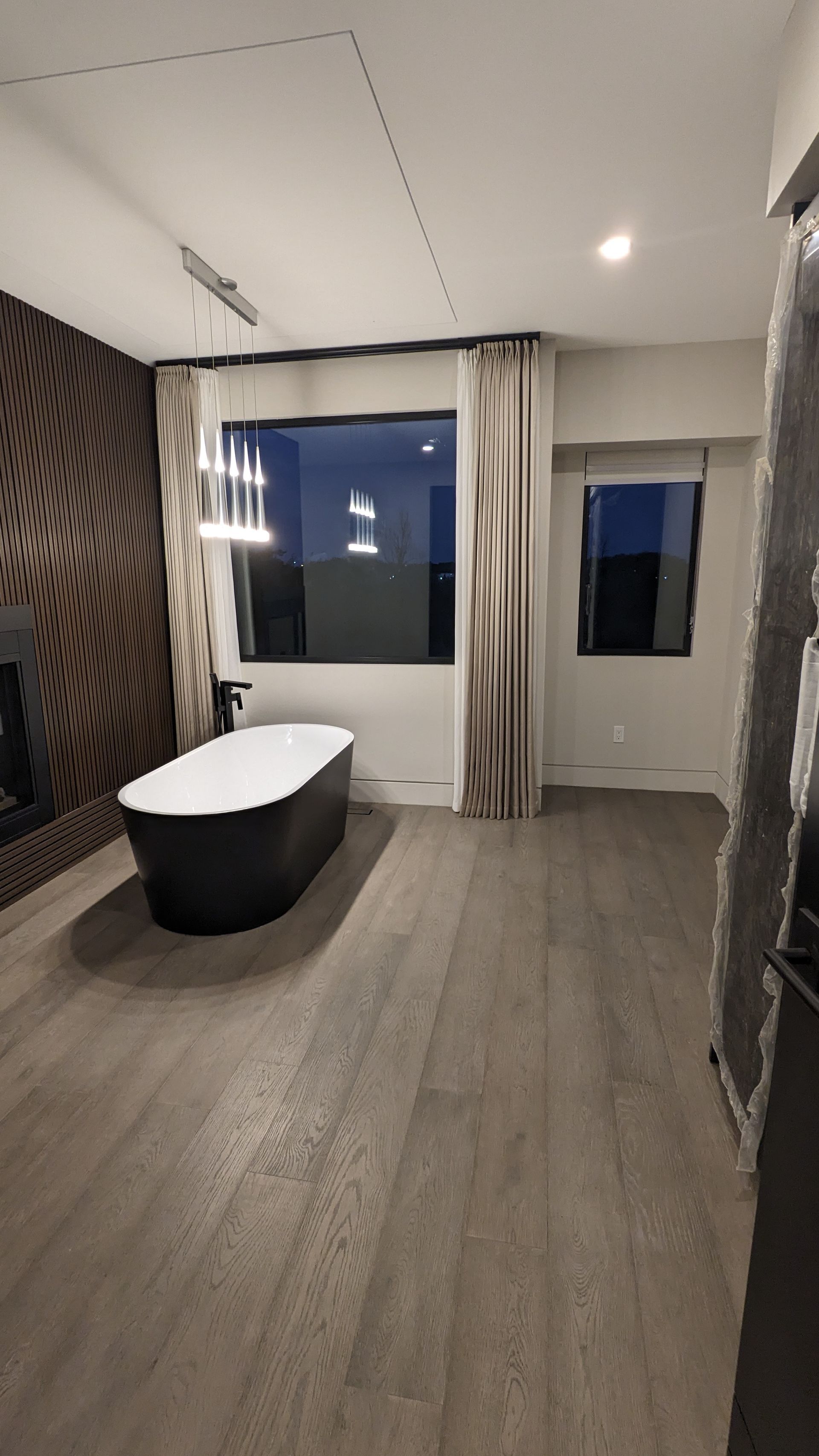 A bathroom with a bathtub and a large window.