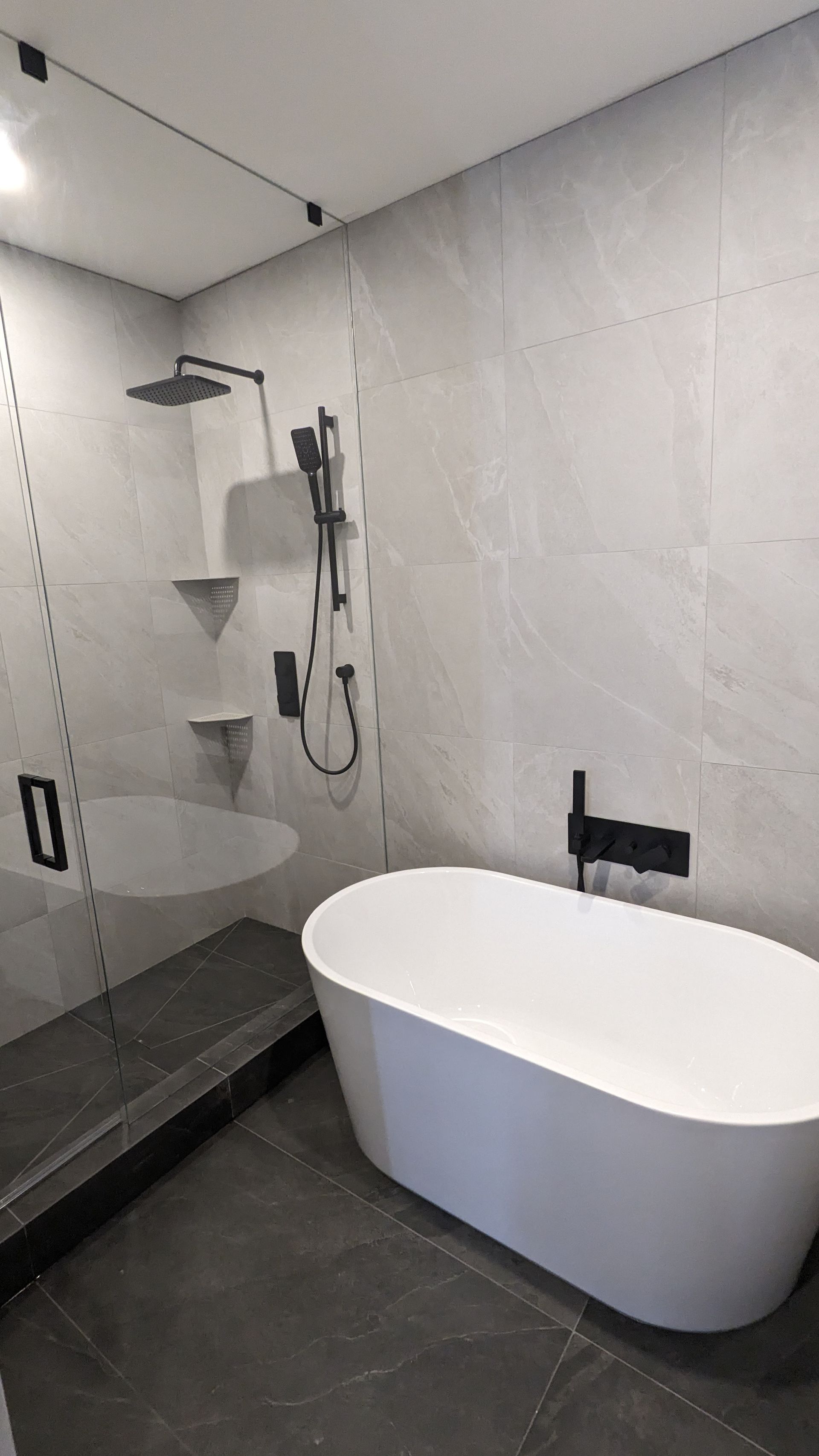 A bathroom with a bathtub , shower , and mirror.