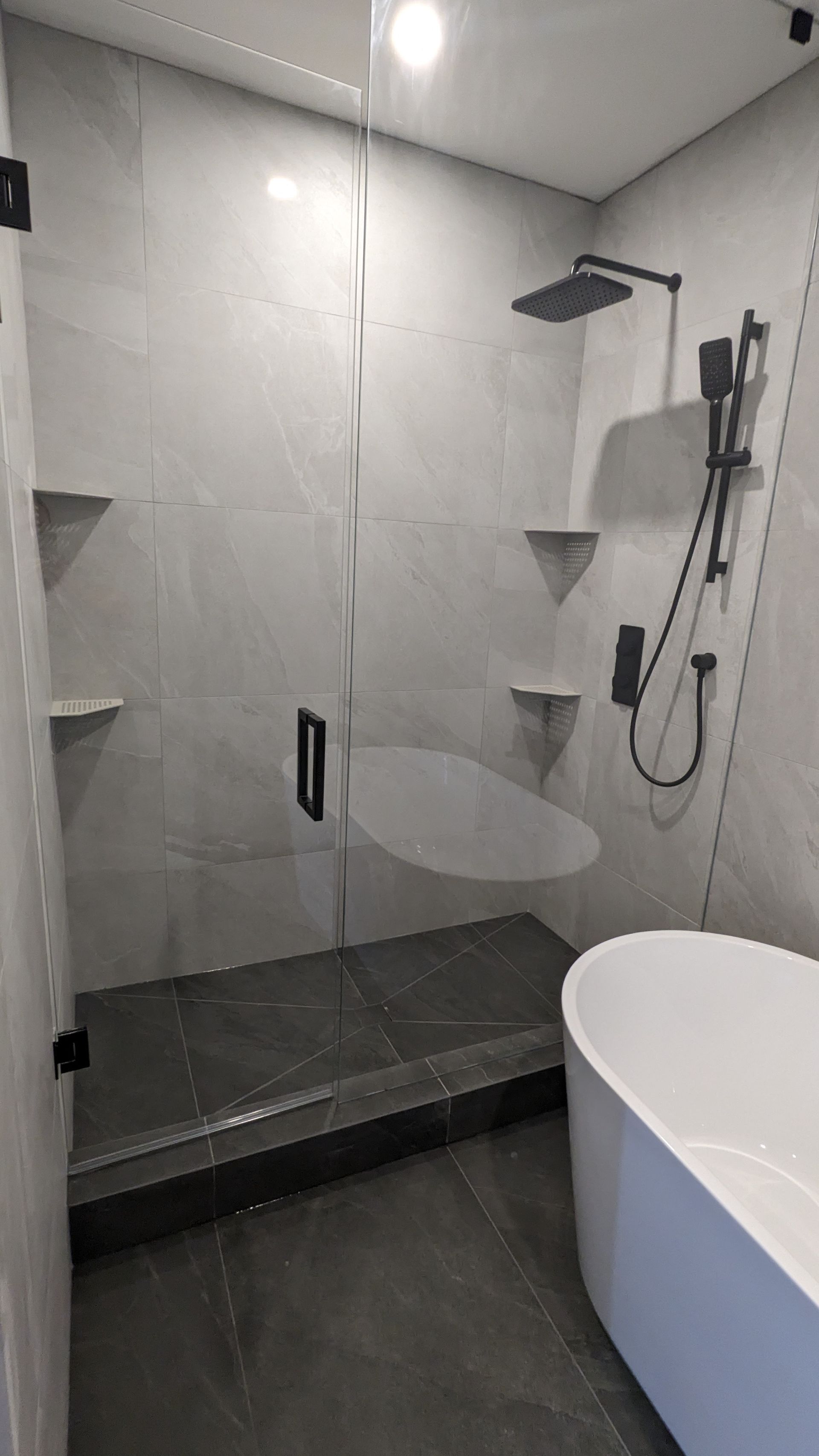 A bathroom with a walk in shower and a bathtub.