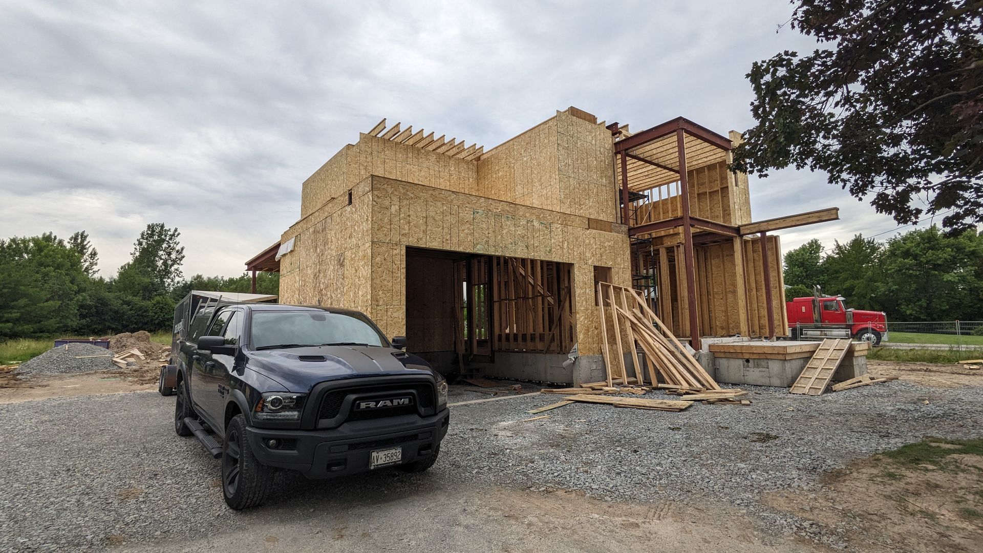 A truck is parked in front of a house under construction.