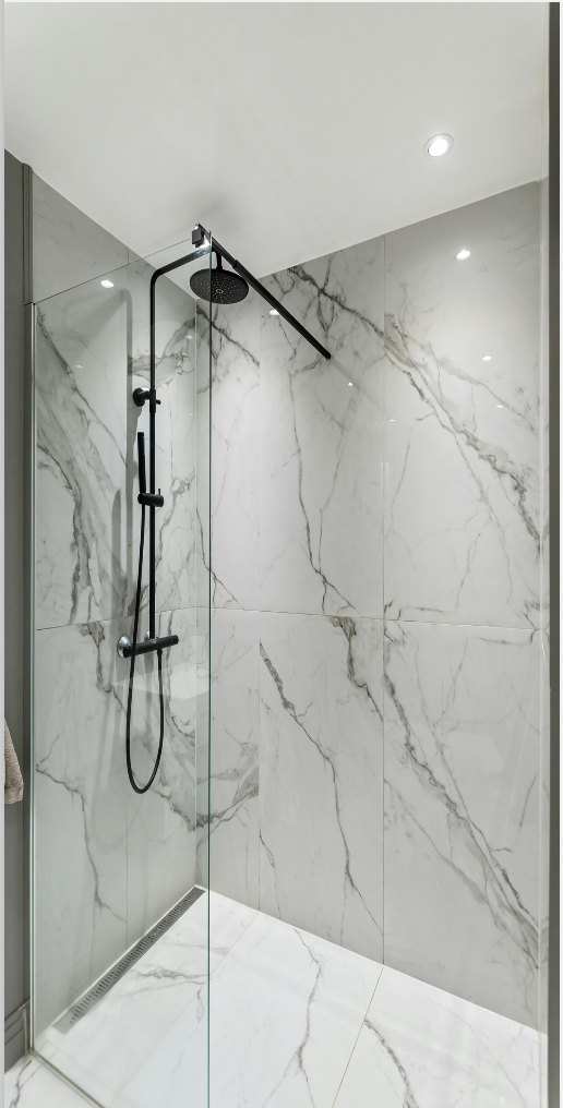 A bathroom with a sink , mirror , soap dispenser and flowers.