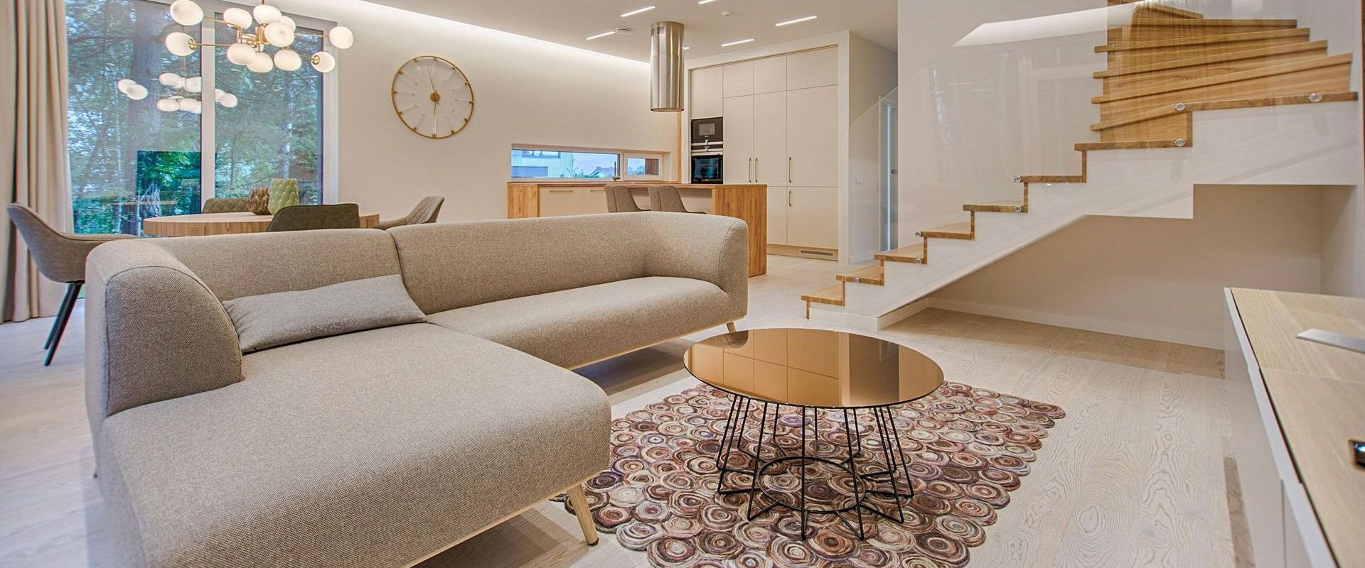 A living room with a couch , table and stairs.