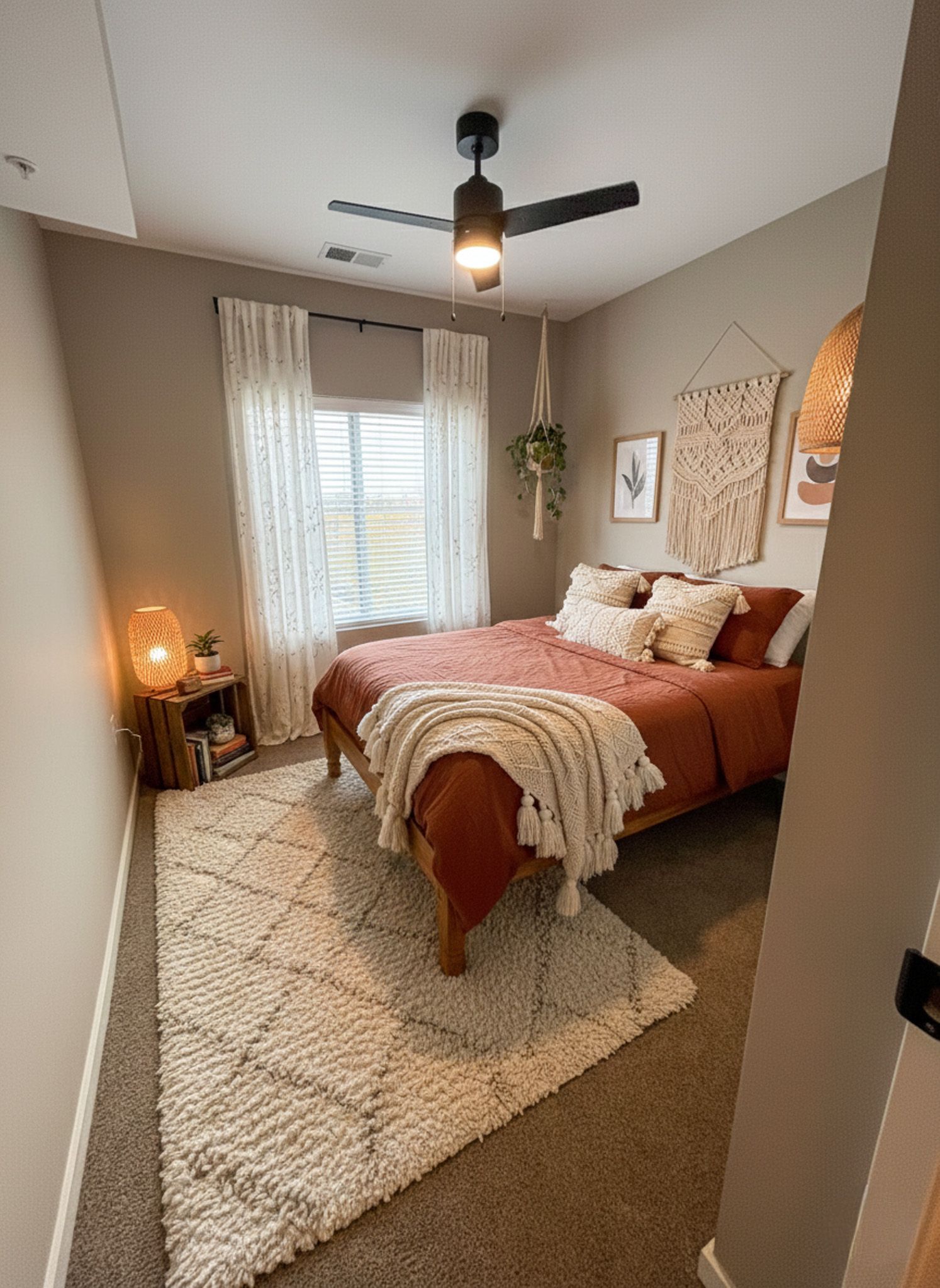 Cozy bedroom with terracotta bedding, cream rug, and bohemian decor.