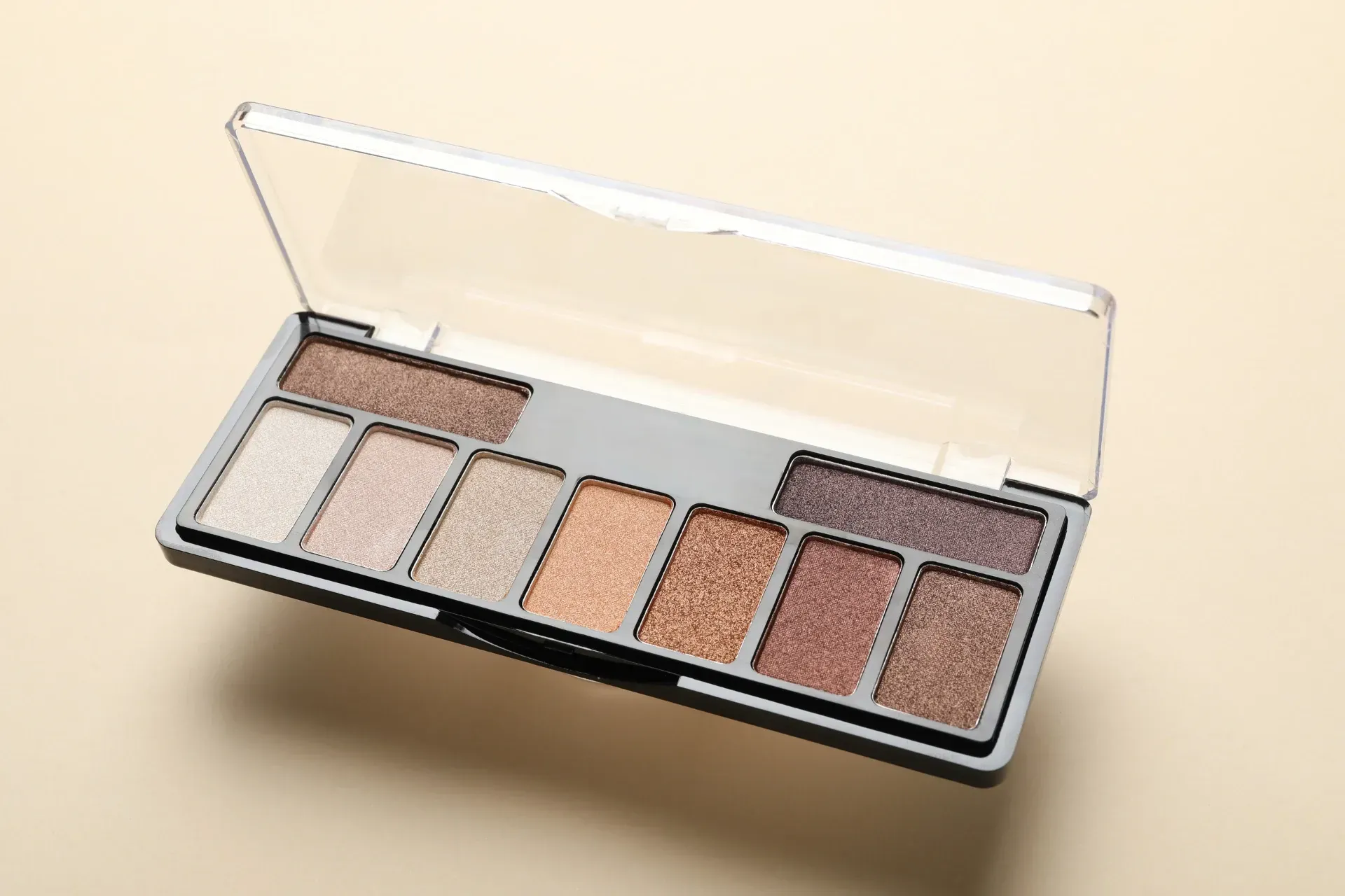 Open neutral-toned eyeshadow palette with multiple shades. 