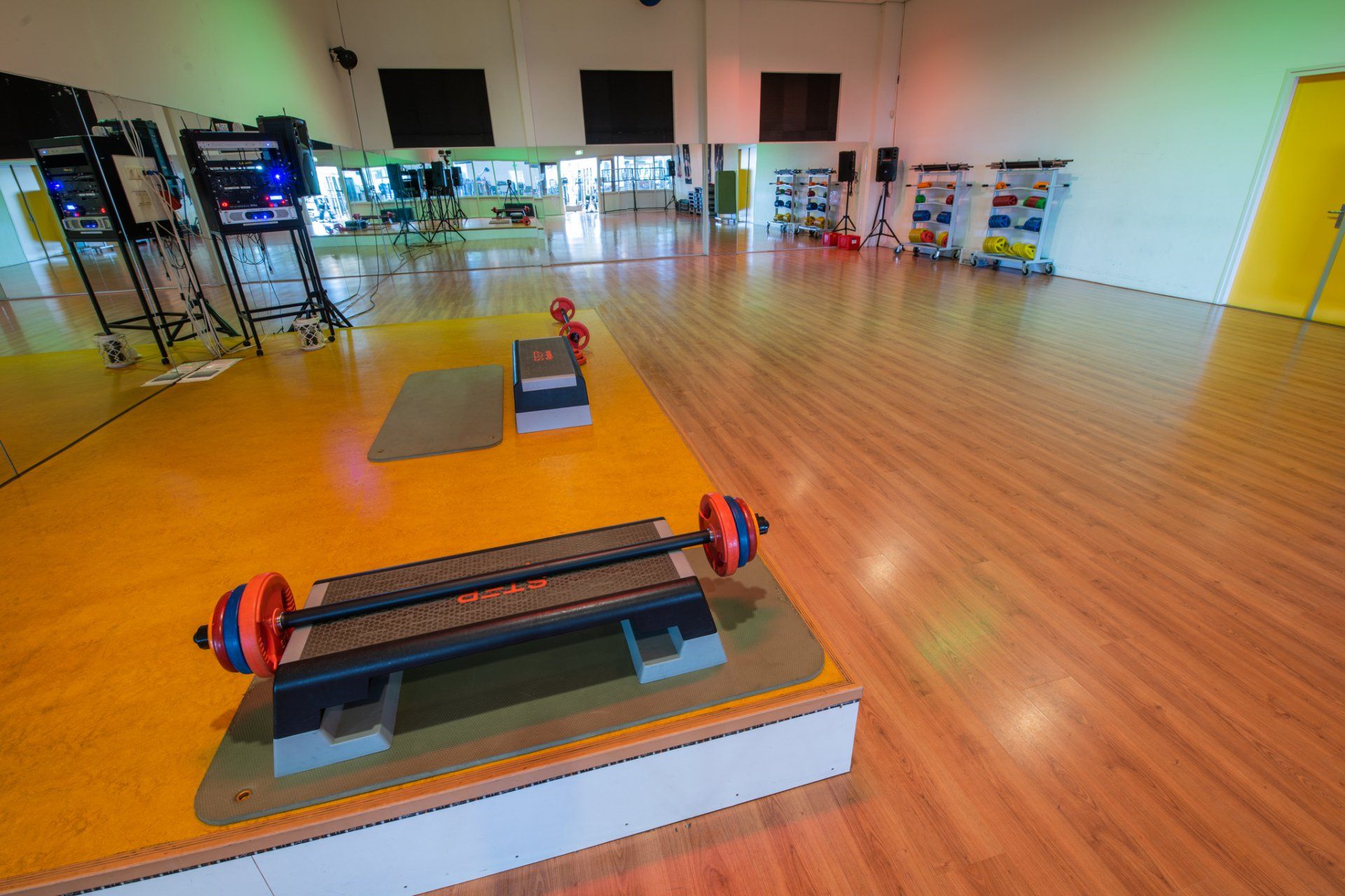 Een gymzaal met een halter op een opstapplatform in het midden van de kamer.