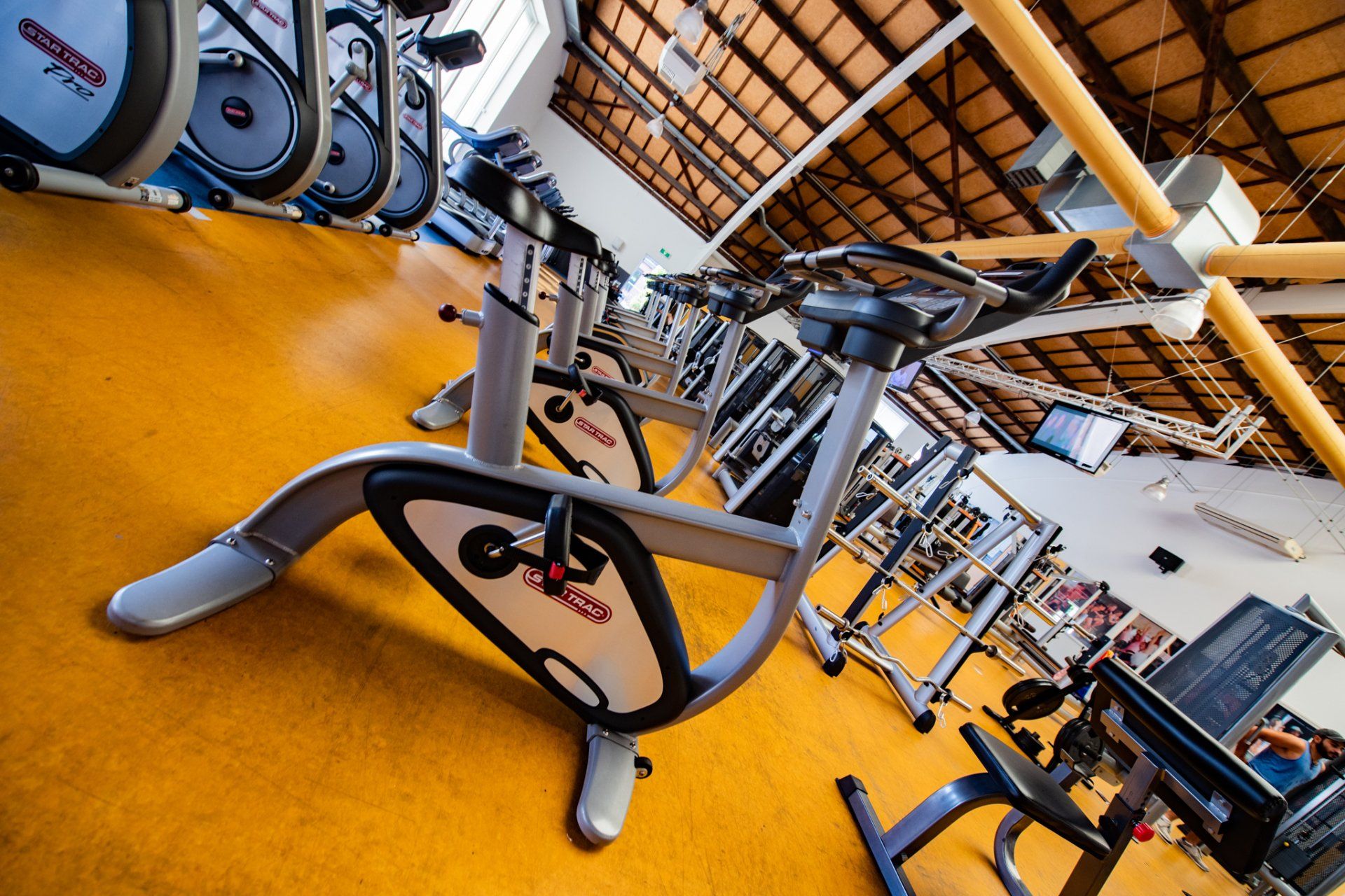 In een sportschool staat een rij hometrainers opgesteld