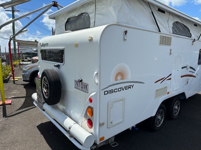 White Jayco Discovery caravan, spare tire, pop-up roof, sunny outdoor setting — Gas Fitting Services in Bundaberg, QLD