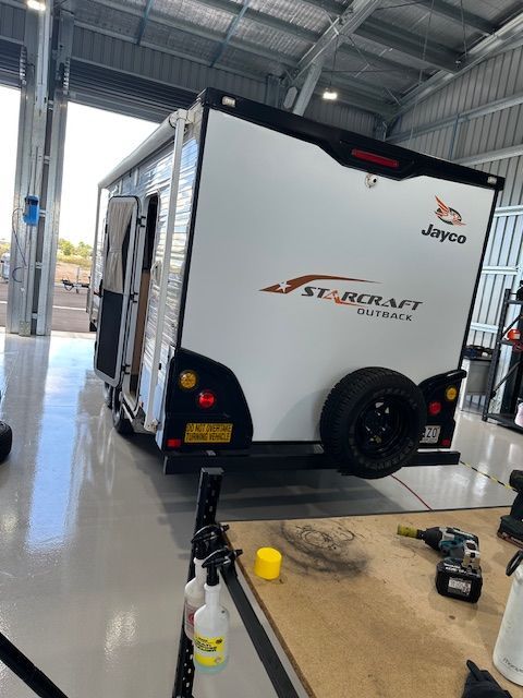 White and black Jayco StarCraft Outback camper trailer parked inside a garage — Gas Fitting Services in Bundaberg, QLD