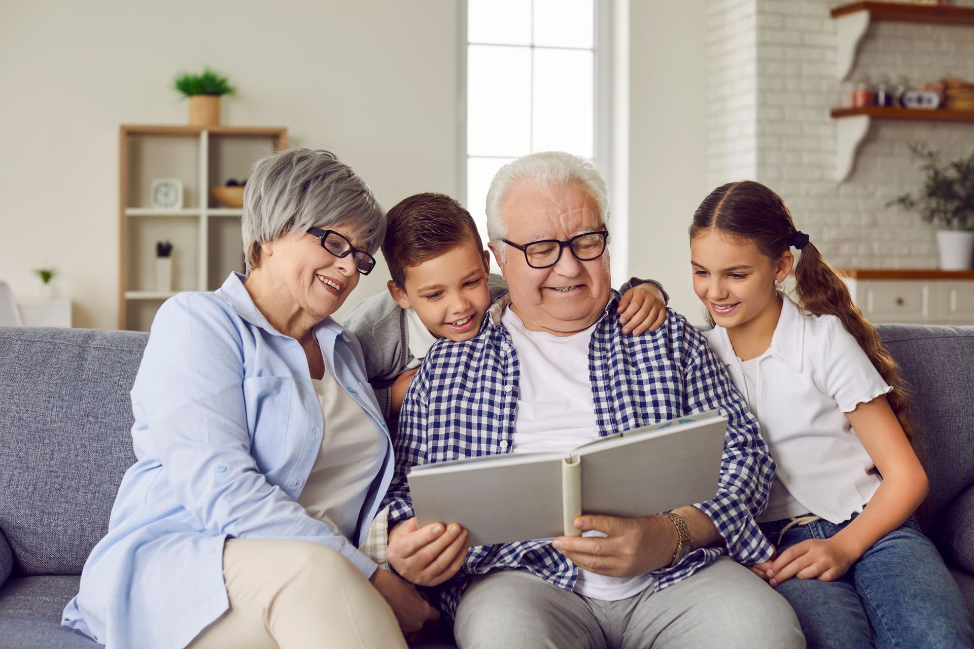 A family is sitting on a couch reading a book together.