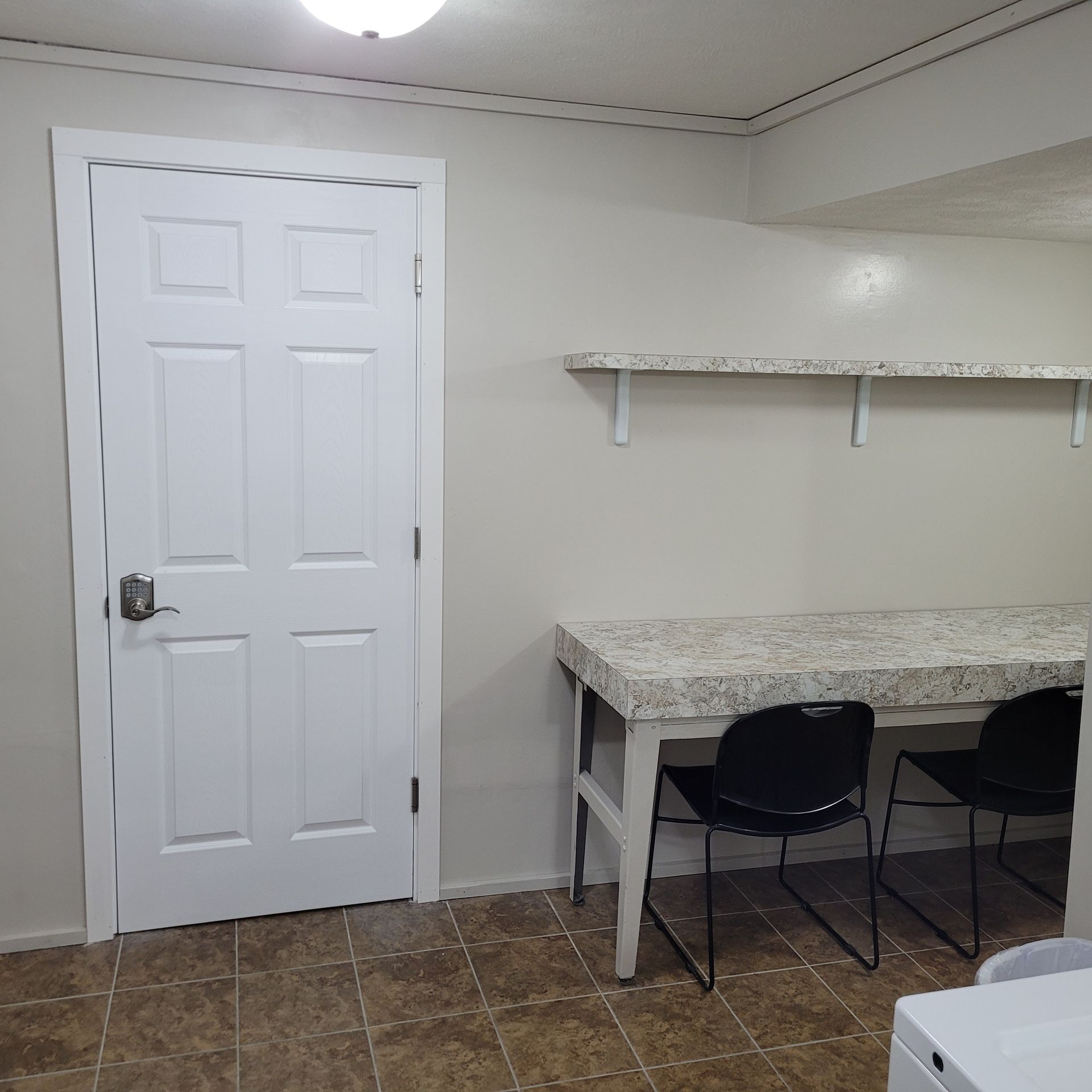 A laundry room with a table and chairs and a washer and dryer.