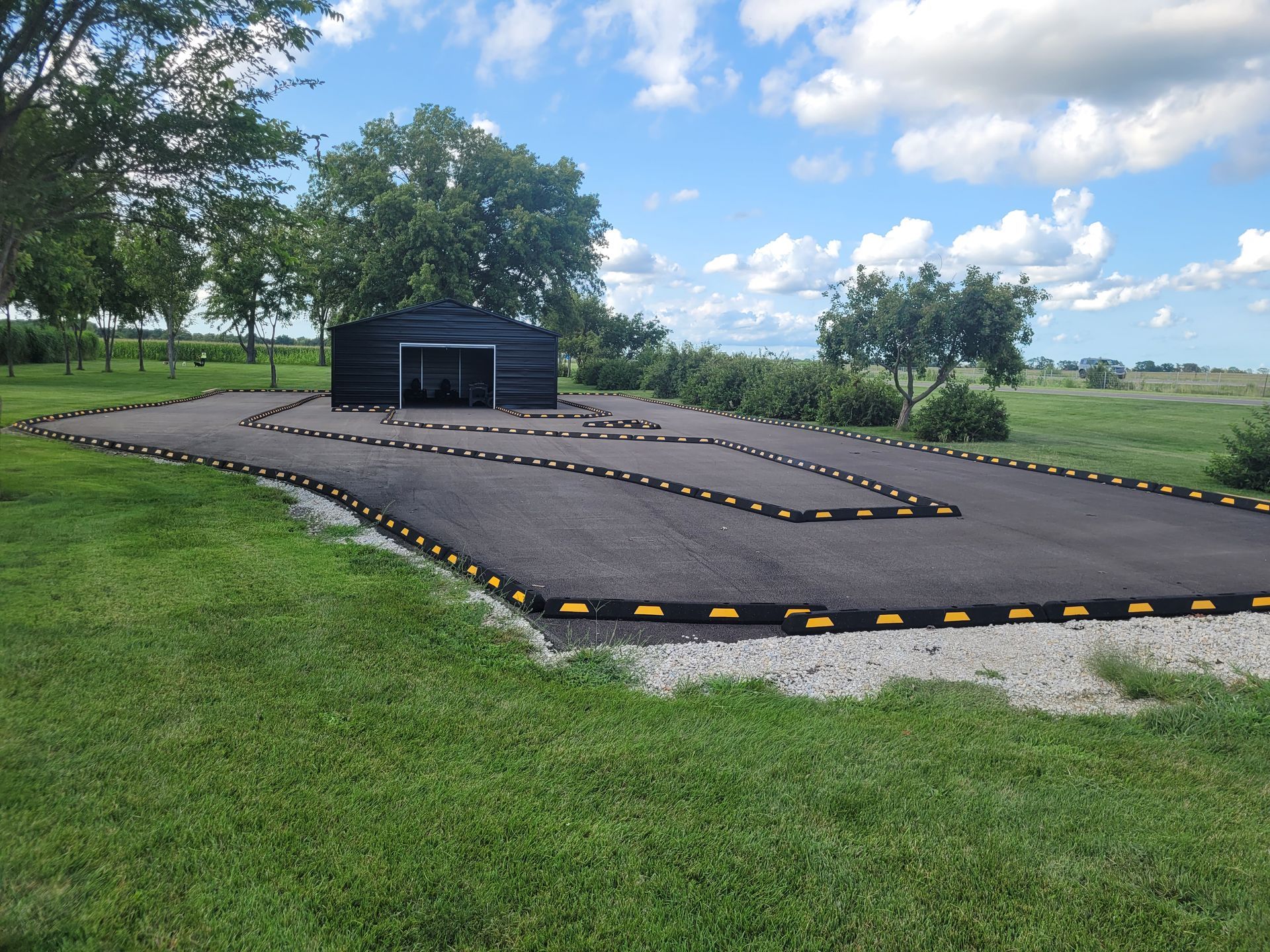 A rc track in a grassy field with a building in the background