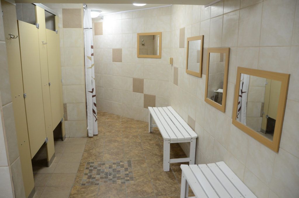 A bathroom with a bench and mirrors in it