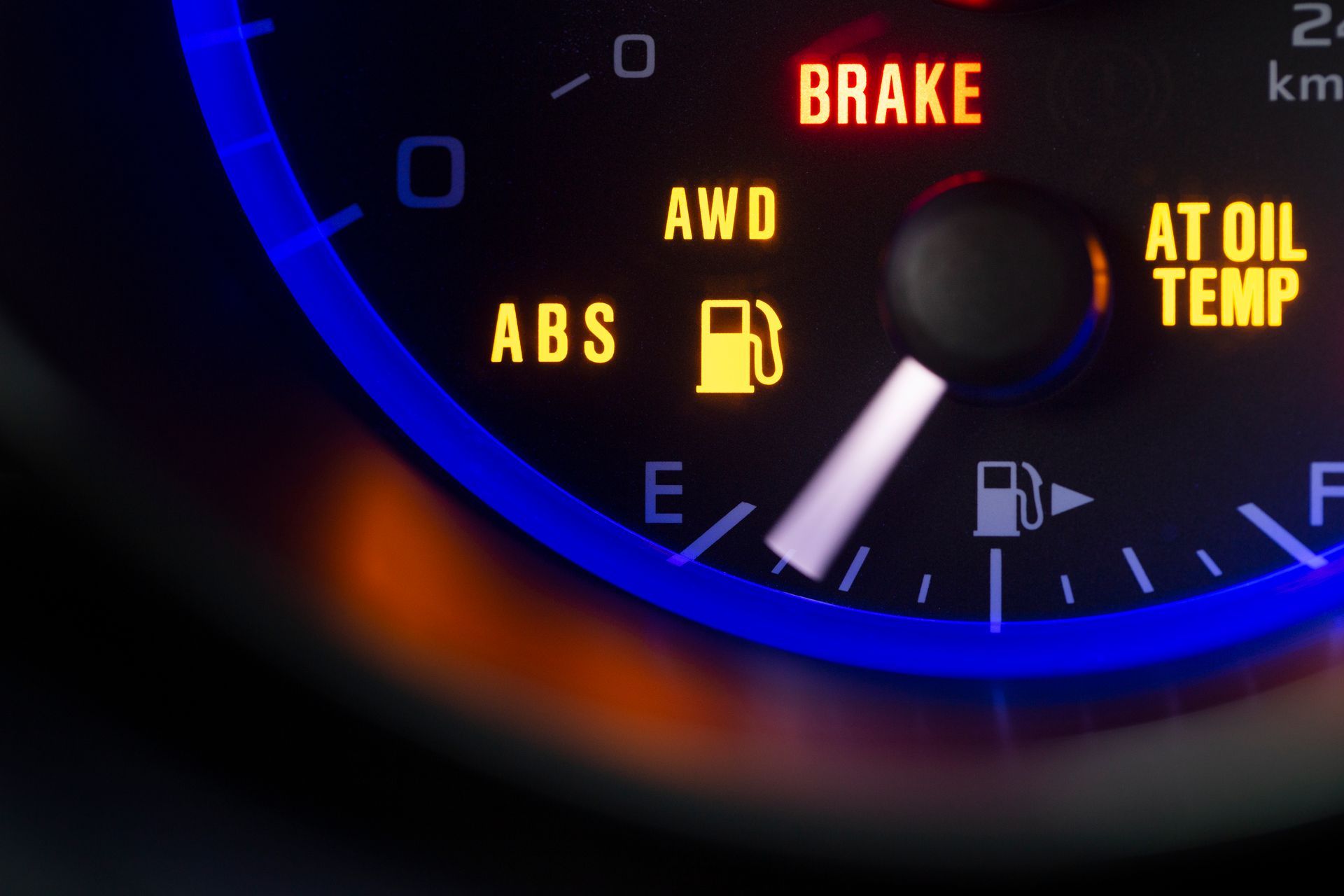 Close-up of a car dashboard displaying multiple warning lights, including ABS, low fuel, brake, AWD, and AT oil temperature.