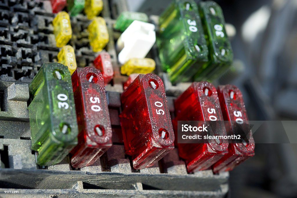 Close-up of colorful car fuses (red 50-amp and green 30-amp) inside a vehicle fuse box – automotive 
