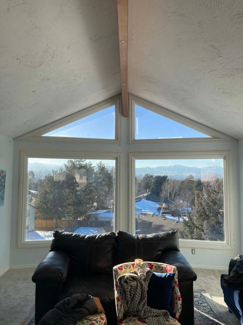 A living room with a couch and chairs and a view of the mountains