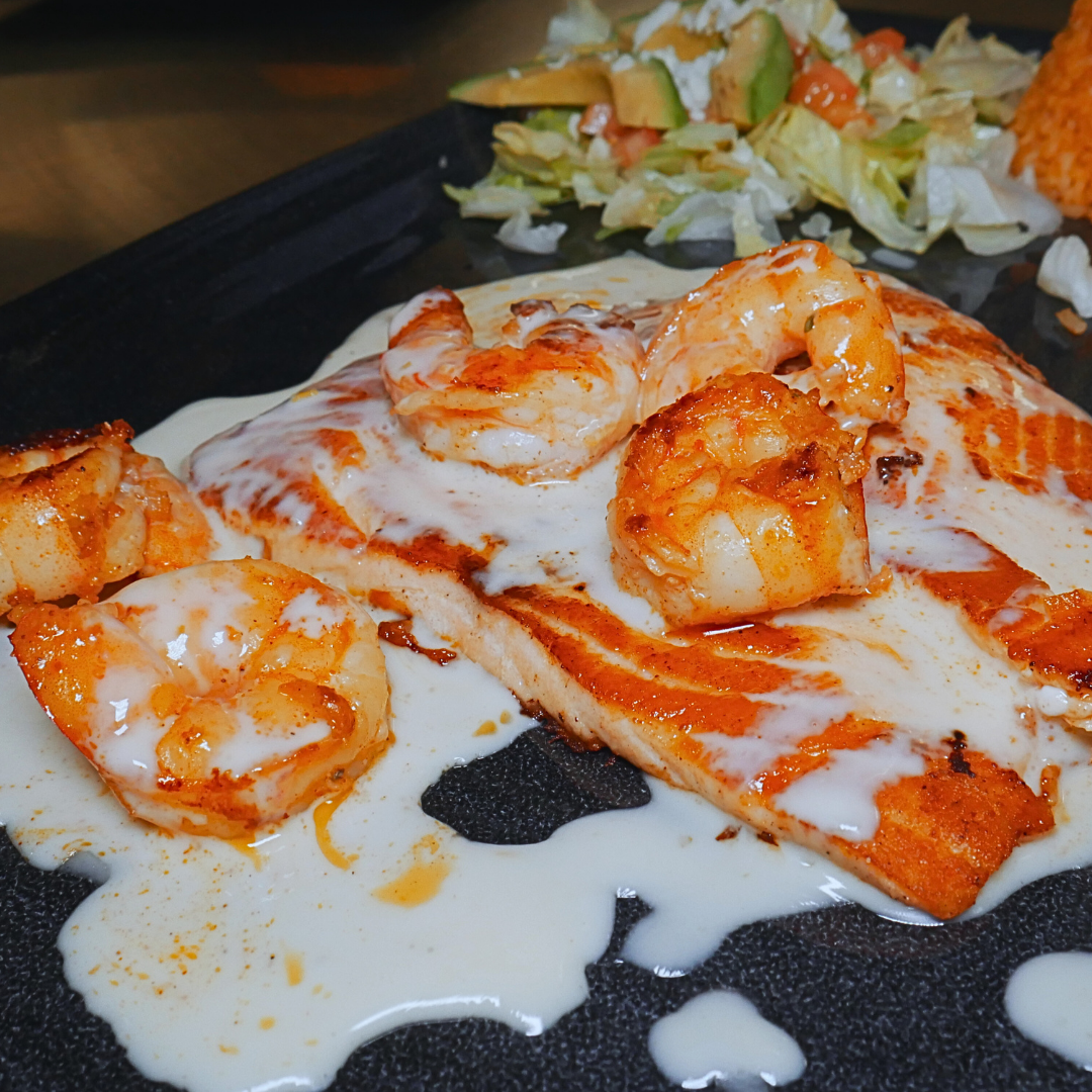 Salmon Caribe entrée at Fiesta Charra Eastwood with grilled shrimp, creamy sauce and salad