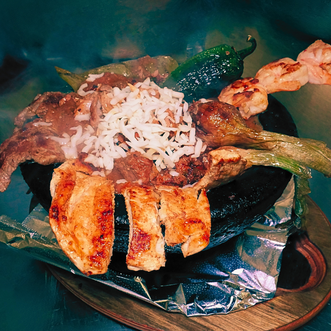 Steak and shrimp molcajete at Fiesta Charra Eastwood with grilled peppers and melted cheese