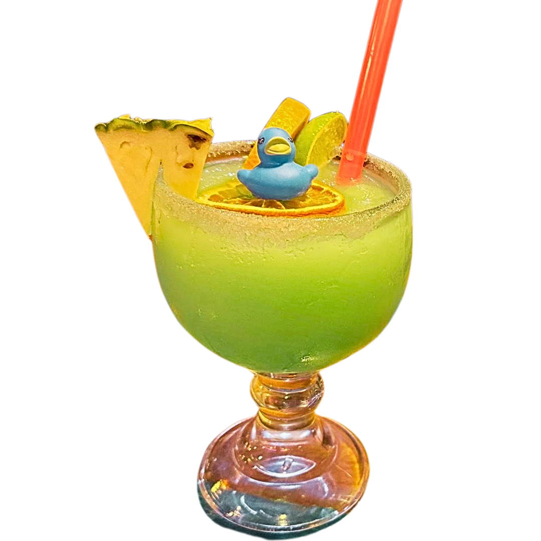 Green cocktail in a goblet, garnished with fruit and a toy duck.