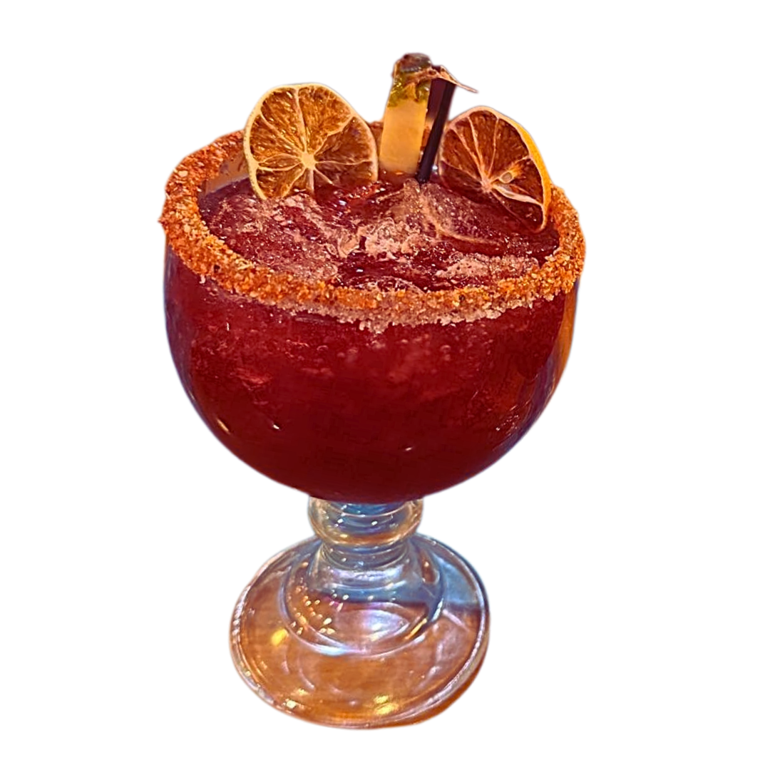 Red cocktail in a glass with a sugared rim, garnished with orange slices and a cinnamon stick.