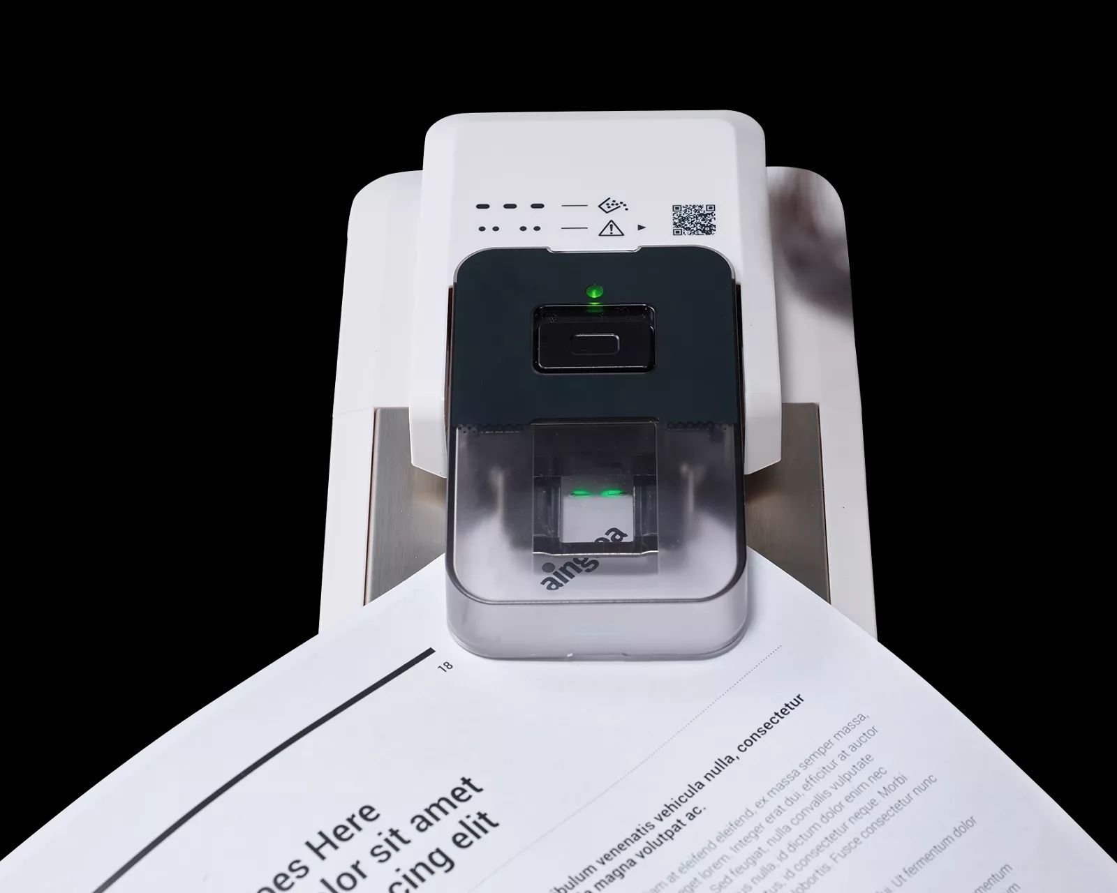 A document scanner scanning a page with text, lit with green indicator lights, on a black background.