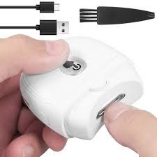 Person holding a white electric nail trimmer. Cables and cleaning brush are in the background.