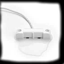 White water sensor on a white surface, with a puddle of water below it.