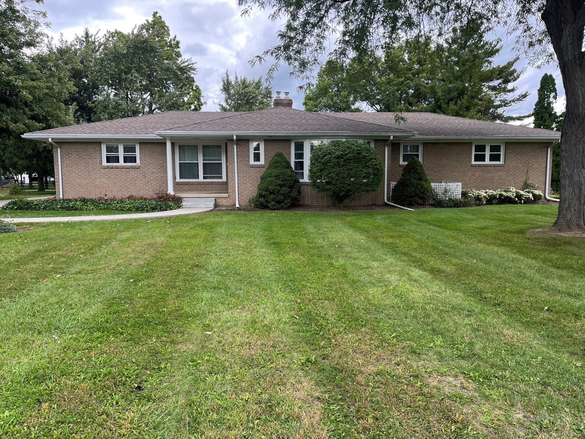A one-story brick duplex with a green lawn in front.