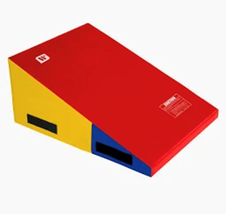 A colorful, red, yellow, and blue gymnastics incline mat for practicing skills.