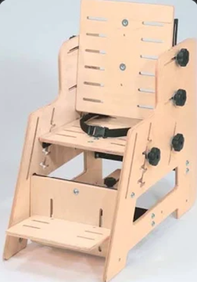 Wooden adaptive seating chair for a child with adjustable back, seat, footrest, and safety belt.