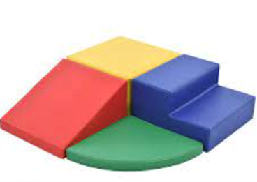 Colorful foam play set: red ramp, yellow square, blue steps, green quarter-circle.