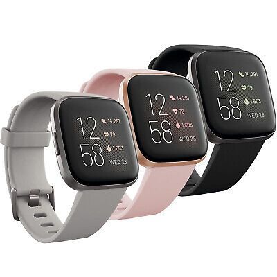 Three FitBit Versa smartwatches in gray, pink, and black.