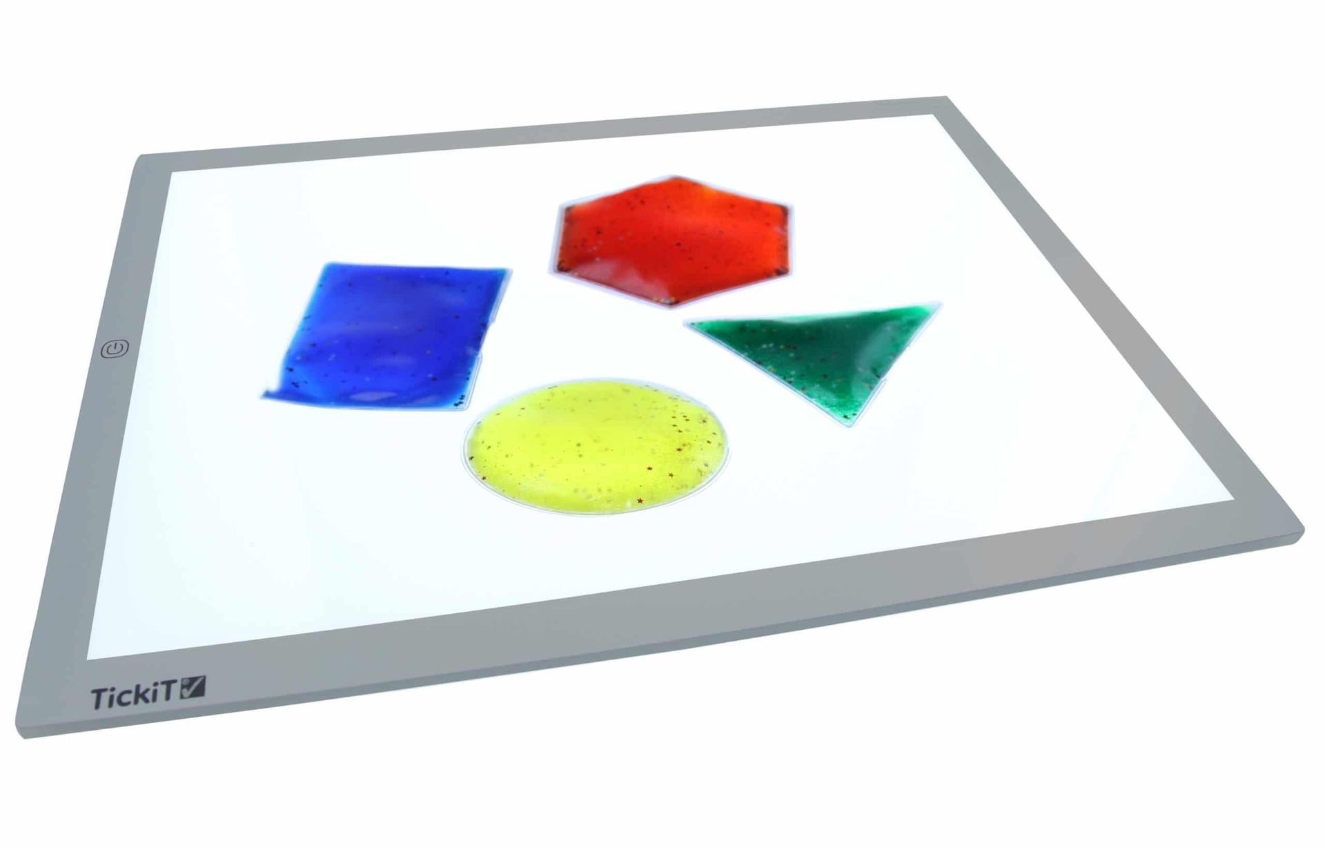 Light table with blue, red, green, and yellow translucent geometric shapes.