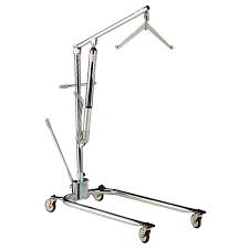 A chrome-colored patient lift with a sling attachment, on wheels, in an indoor setting.