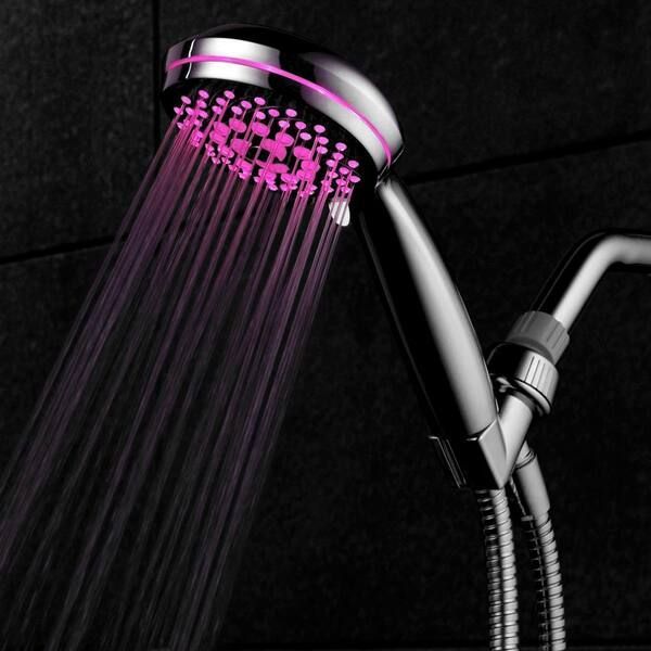 Silver shower head with pink illuminated water streams against a dark tile wall.