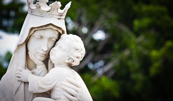 Eine Statue einer Frau, die ein Kind mit einer Krone auf dem Kopf hält.