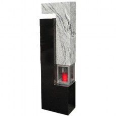 Eine schwarz-weiße Marmor-Skulptur mit einer roten Kerze darin.