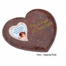 Ein herzförmiger Grabstein mit dem Bild eines Babys darauf.