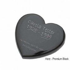Eine schwarze herzförmige Urne mit dem Namen Carola Tester darauf.