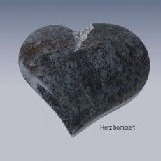 Ein schwarzer herzförmiger Stein mit einem Loch in der Mitte.