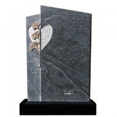 Ein Grabstein mit einem Herz und Blumen darauf.